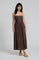 woman wearing a brown pleated maxi dress with spaghetti straps and flat sandals