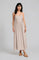 woman wearing a beige spaghetti strap maxi dress with pleated details and standing in a neutral background
