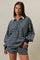 woman wearing a navy and gray striped oversized polo top with a contrasting white collar and matching shorts