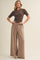 woman wearing a brown short sleeve knit top and tan wide-leg pants with a drawstring waist