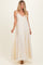 woman wearing a cream maxi dress with adjustable straps and tiered skirt