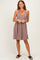woman wearing a ribbed brown sleeveless dress with a scoop neckline and a flared skirt