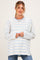 woman wearing a white and light blue striped maternity sweatshirt with a relaxed fit and side slits