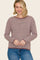 woman wearing a maroon and cream striped long sleeve sweater with a relaxed fit and round neckline