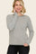 woman wearing a gray and white striped long sleeve sweater with a relaxed fit and round neckline