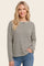 woman wearing a black and cream striped long sleeve top with a relaxed fit and round neckline