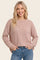 woman wearing a striped long sleeve oversized top in pastel colors with a relaxed fit and a round neckline