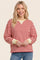 woman wearing a red and white striped long sleeve pullover with yellow trim and blue jeans