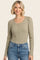 woman wearing a striped long sleeve henley top with buttons and puff sleeves paired with light wash jeans