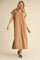 woman wearing a tan short sleeve maxi dress with a collar and rolled sleeves
