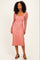 woman wearing a dusty rose long sleeve floral midi dress with a fitted silhouette and scoop neckline