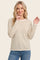 woman wearing a cream and beige striped long sleeve top with a rounded neckline and relaxed fit