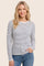 woman wearing a gray and white striped long sleeve top with a round neckline and relaxed fit
