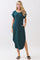 woman wearing a teal short sleeve maxi dress with pockets and side slits, styled with flat sandals