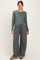 woman wearing a green long sleeve ribbed maternity top and gray wide-leg maternity sweatpants, smiling