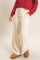 woman wearing cream wide-leg lounge pants with pockets and a red textured sweater
