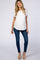 woman wearing a white short sleeve maternity top and blue skinny jeans, with a visible baby bump