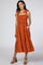 woman wearing an orange tiered summer dress with tie straps and pockets, standing in a casual pose