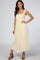 woman wearing a cream smocked maxi dress with a one-shoulder tie detail and a flowy skirt