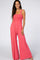 woman wearing a coral smocked bodice jumpsuit with wide legs and pockets