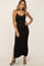 woman wearing a black ribbed maxi dress with a side slit and spaghett straps