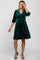 woman wearing a green velvet maternity dress with three-quarter sleeves and a v-neck, showing her baby bump