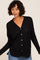 woman wearing a black button-up cardigan with a v-neck and relaxed fit, paired with blue jeans
