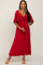 woman wearing a red maxi dress with a front tie, short flutter sleeves, and a relaxed fit