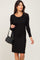 woman wearing a black long sleeve dress with a twist detail, holding a black handbag