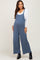 woman wearing a blue maternity jumpsuit with a white long sleeve top and a visible baby bump