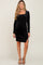 woman wearing a black long sleeve maternity dress with a square neckline and side slit