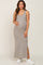 woman wearing a striped beige maternity maxi dress and holding her baby bump