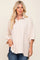 blonde woman wearing an oversized beige button-down shirt and blue jeans