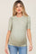 woman wearing a green short sleeve maternity top with floral print and ruched sides, showing her baby bump