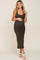 woman wearing an olive green fitted maternity dress, showing her baby bump, styled with white sandals