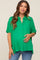 woman wearing a bright green short sleeve maternity shirt and holding her baby bump
