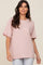 woman wearing a light pink oversized t-shirt with short sleeves and a front pocket.