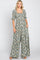 woman wearing a floral print maxi dress with a square neckline and puff sleeves, standing with hands in pockets