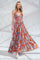 woman wearing a floral maxi dress with a smocked bodice and spaghetti straps, standing against a light background