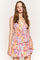 woman wearing a colorful floral print tiered mini dress with a deep v-neckline and ruffled details