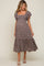 woman wearing a brown floral maternity dress with short ruffled sleeves and a tiered hem, showcasing her baby bump