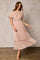 woman wearing a blush pink glittery maxi dress with flutter sleeves and ruffle hem detail