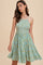 woman wearing a green floral sundress with a smocked bodice and a flared skirt
