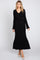 woman wearing a black ribbed knit maxi dress with a v-neck and long sleeves, featuring a tied waist detail
