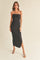 woman wearing a black ribbed halter neck maxi dress with a twisted front detail