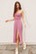 woman wearing a pink floral midi dress with a side slit and spaghetti straps, styled with beige sneakers