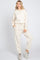 woman wearing a cream oversized sweatshirt and matching joggers, styled with a relaxed fit and side pockets