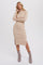 woman wearing a beige ribbed knit midi dress with side slit and long sleeves, paired with snake print ankle boots