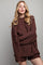 woman wearing a burgundy oversized knitted sweater with long sleeves and matching shorts