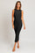 woman wearing a black ribbed midi dress with a sleeveless design and form-fitting silhouette